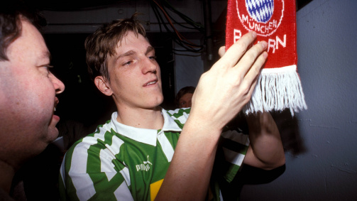 Werder Bremens Andreas Herzog unterschreibt im Dezember 1994 auf einem Fan-Schal des FC Bayern, seinem späteren Arbeitgeber
