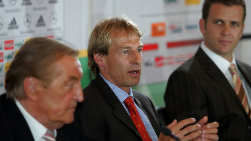 29. Juli 2004: Der neue Bundestrainer Jürgen Klinsmann bei seiner Präsentation, neben ihm lauschen DFB-Präsident Gerhard Mayer-Vorfelder (l.) und Teammanager Oliver Bierhoff (r.)